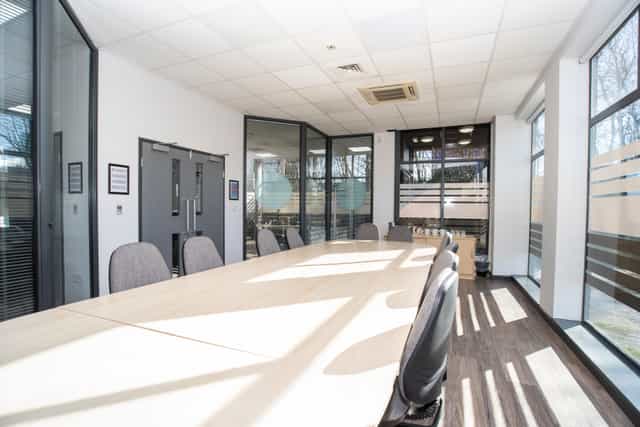 Modern conference room with spacious table and natural light for meetings and events.