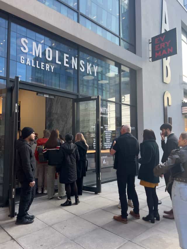 Attendees queue outside Smolensky Gallery for a well-organized art event in Manchester.