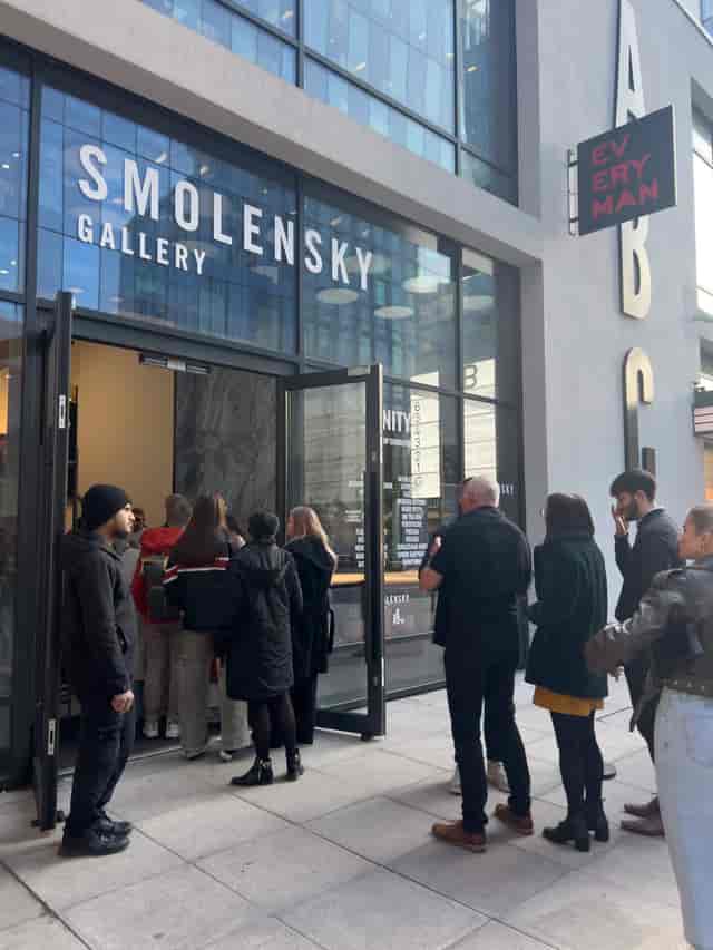 Attendees queue outside Smolensky Gallery for a well-organized art event in Manchester.