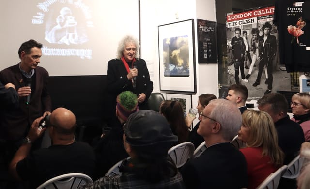 Engaging speaker at dynamic event in Proud Galleries with creative backdrop and interactive seating.