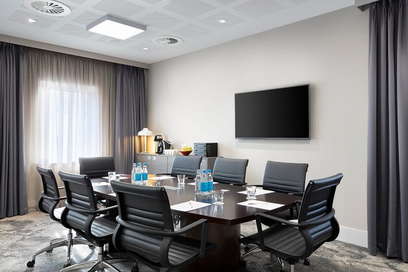 Modern conference room with sleek table, ideal for meetings and presentations at Hampton by Hilton.