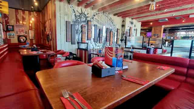 Semi-private dining area at TGI Friday's Brighton Marina with red leather seating.