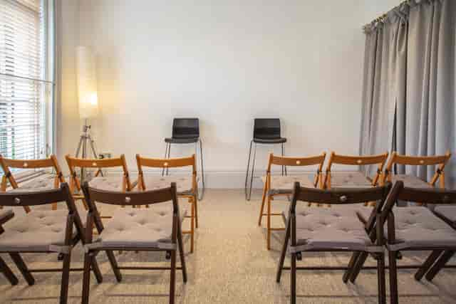 Minimalist meeting space with folding chairs for intimate workshops and team gatherings.