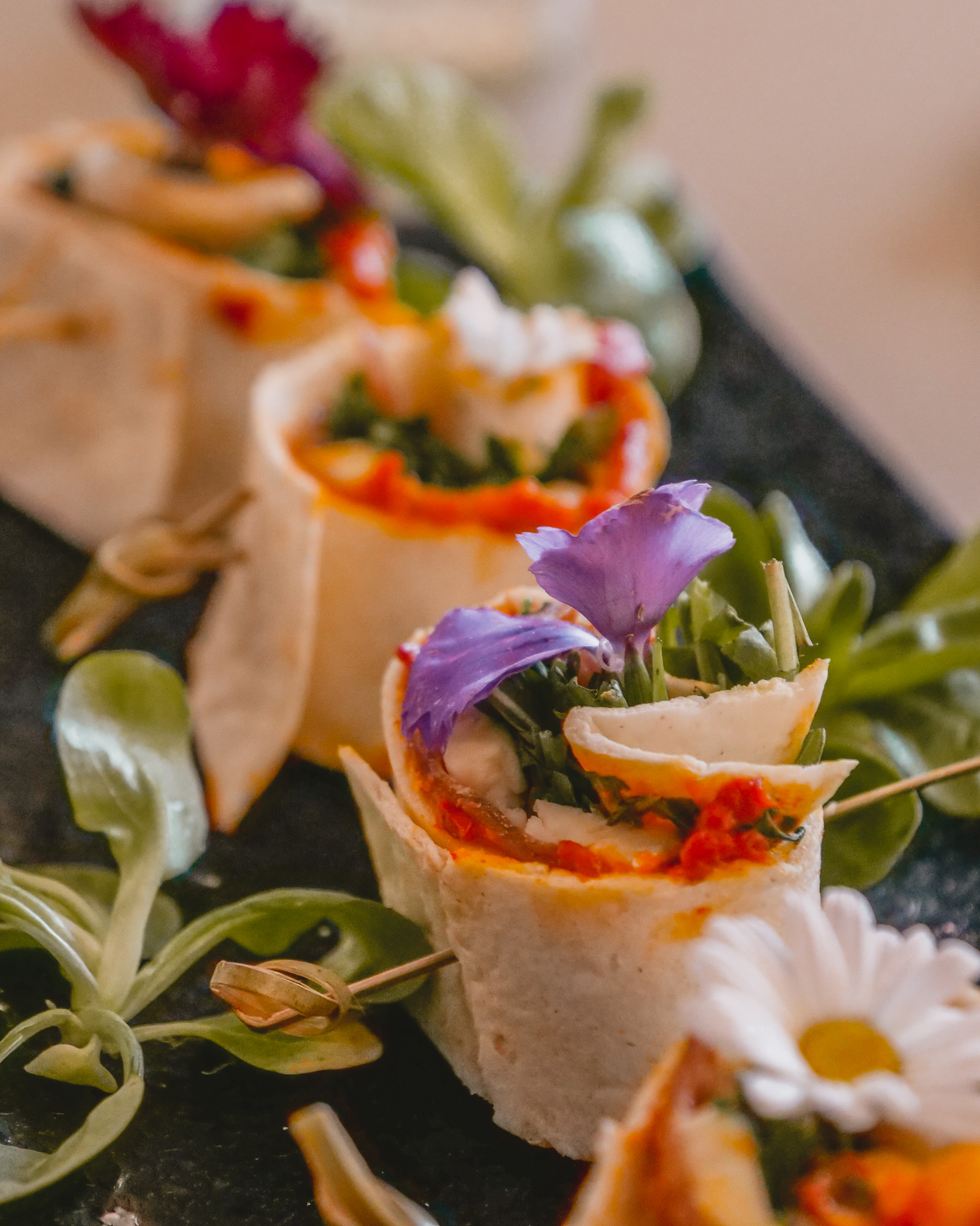 Vita Boutique Fitness appetizer: rolled tortillas with vibrant ingredients and flowers. - Banner