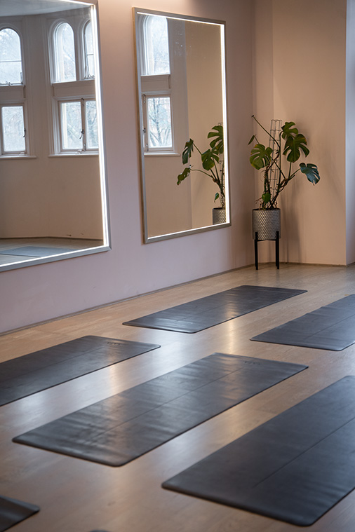Serene yoga studio with mirrored walls, perfect for wellness retreats and team-building events. - Banner