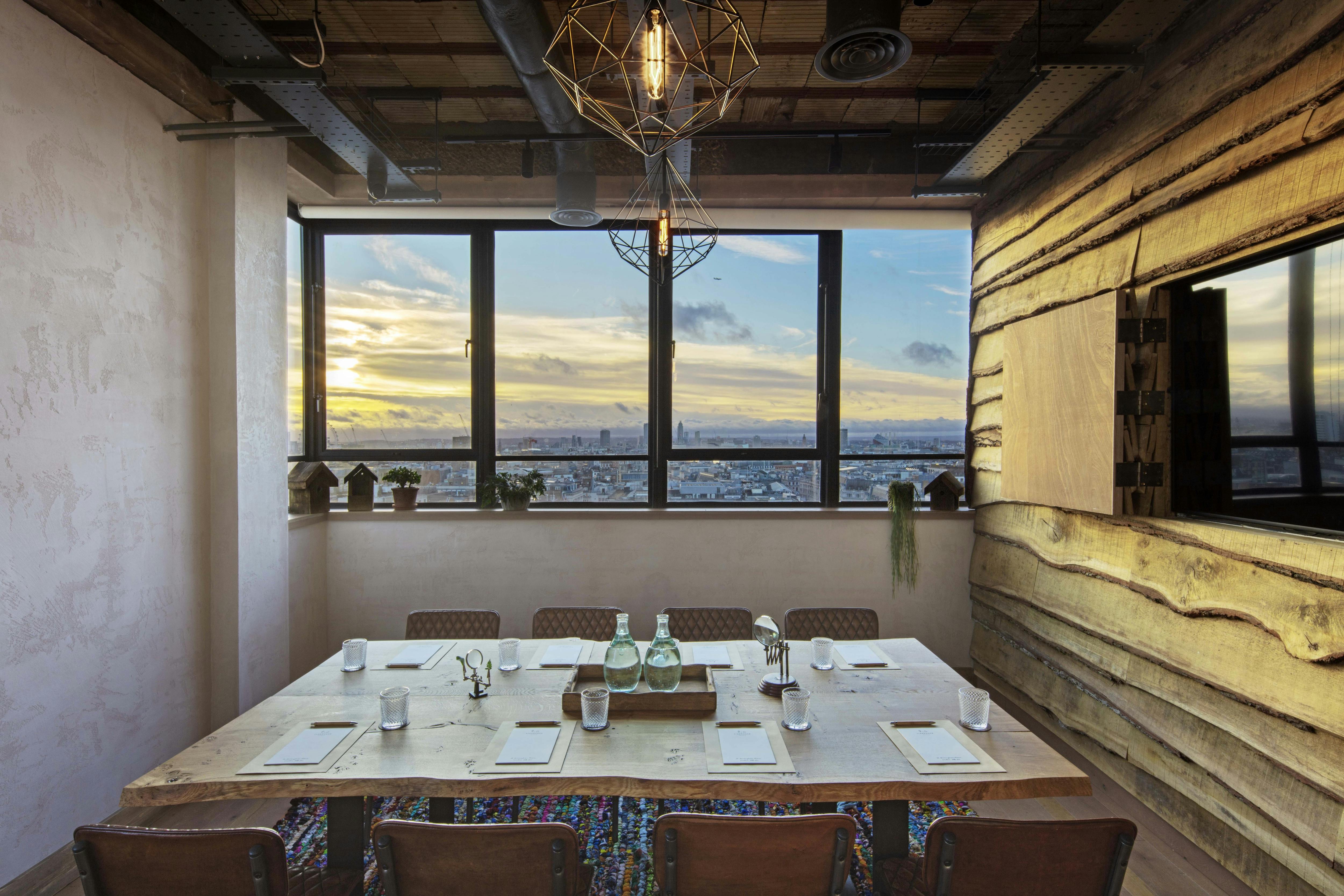 Stylish meeting room with wooden table and city views at The Treehouse Hotel.