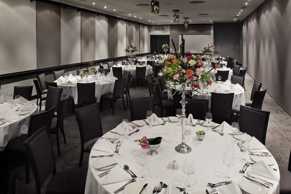 Elegant Optima Ballroom dinner setup with white linens, perfect for corporate events and weddings.