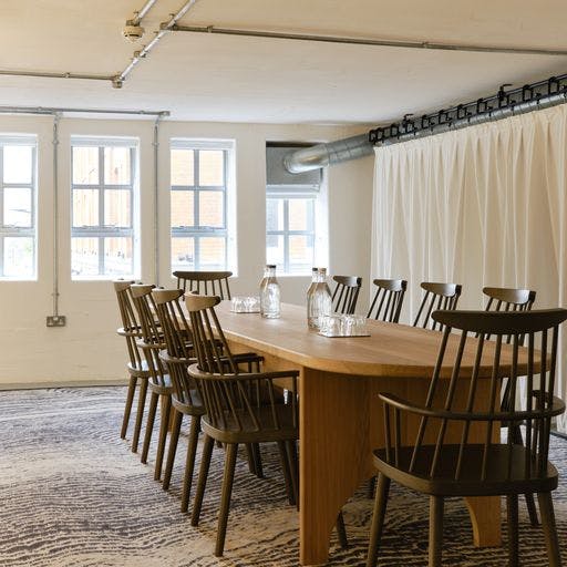 Modern meeting room with wooden table and high-backed chairs in Shoreditch Arts Club.