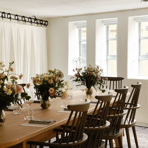 Elegant meeting space with wooden table and floral centerpieces in Shoreditch Arts Club.