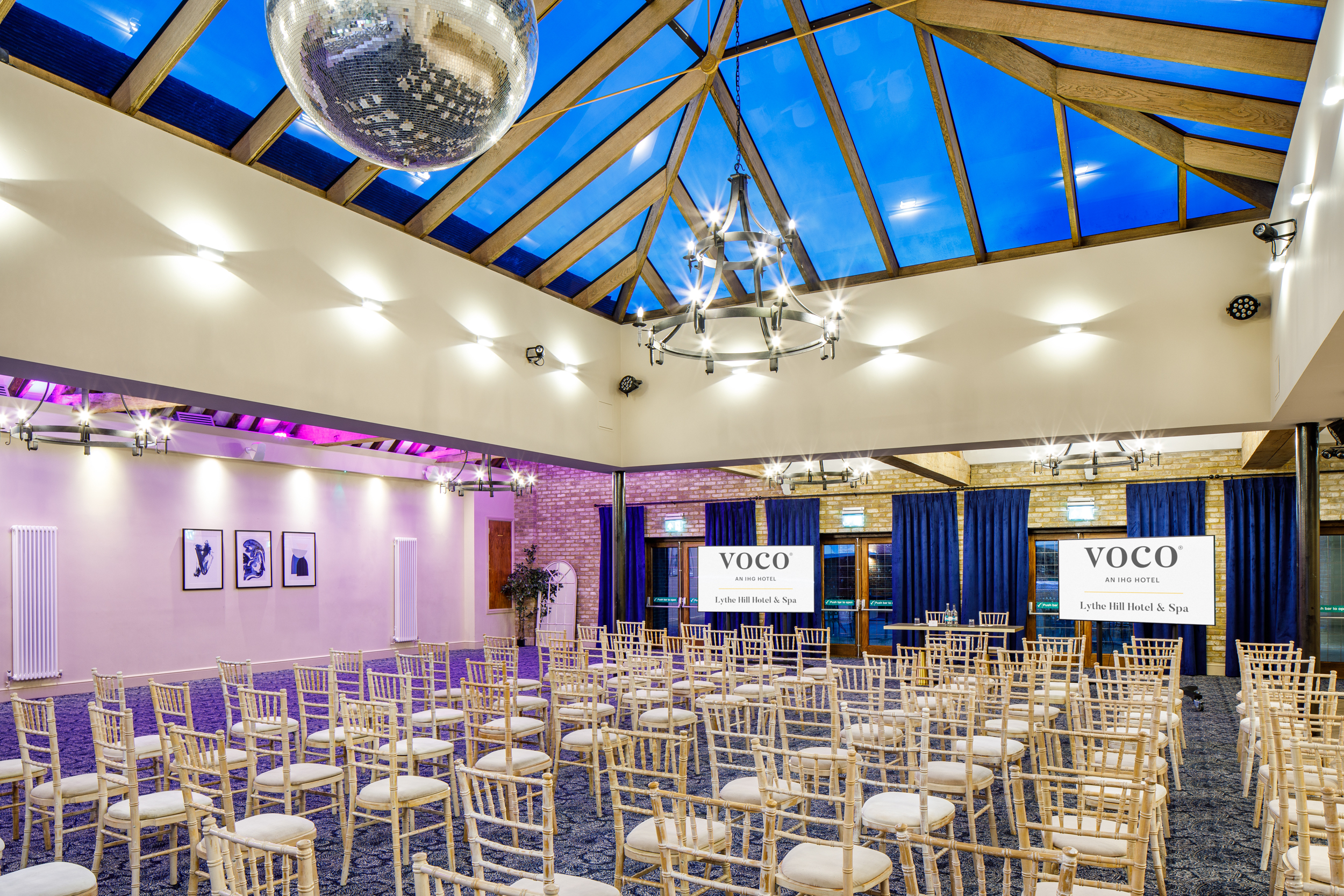 Hazel Suite at Voco Lythe Hill: elegant event space with wooden beams, ideal for conferences. - Banner