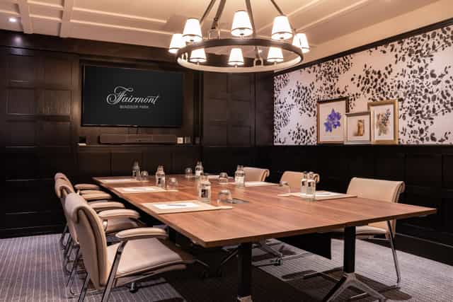 Sophisticated meeting room with wooden table at Fairmont Windsor Park for professional events.