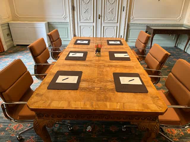 Lavender meeting room at Warren House Hotel with wooden table and leather chairs.
