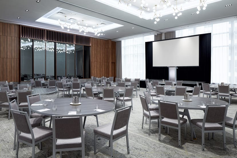 Event space at Hilton Garden Inn Montreal with round tables for networking and presentations.