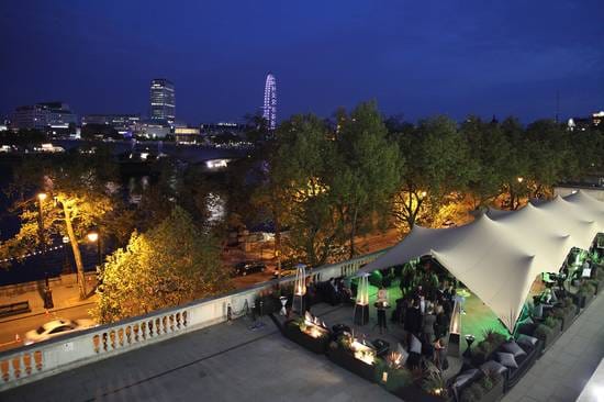 Elegant outdoor event space at Somerset House with illuminated tent and lush greenery.