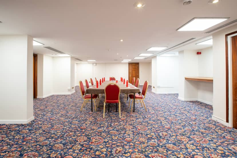 Cromwell 6 meeting room in Kensington with elegant red chairs for conferences and workshops.