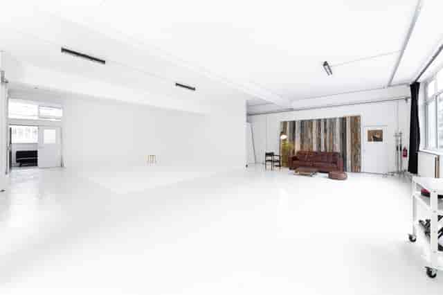 Versatile event space with bright white walls, perfect for workshops and photo shoots.