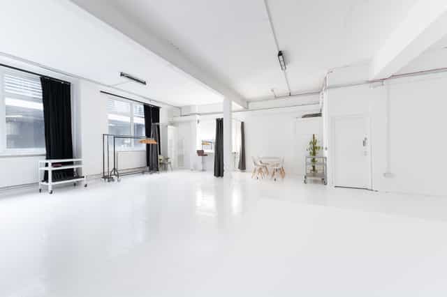 Versatile minimalist event space with natural light for meetings and workshops.