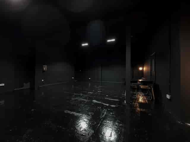 Versatile minimalist event space with dark walls for creative meetings and workshops.