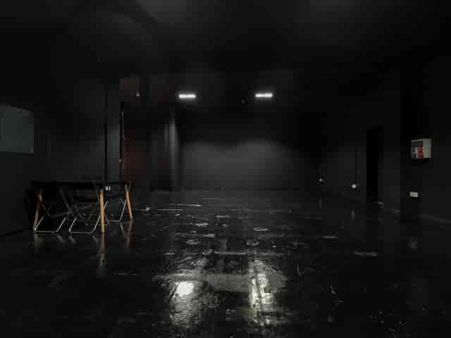 Versatile minimalist event space with dark walls for creative meetings and workshops.