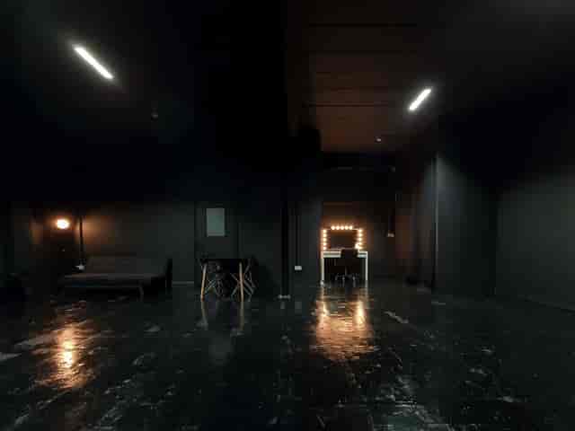 Versatile event space with dark walls, ideal for intimate gatherings and workshops.
