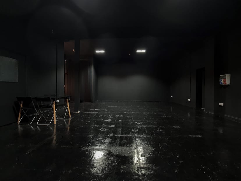 Versatile minimalist event space with sleek black interior for workshops and gatherings.