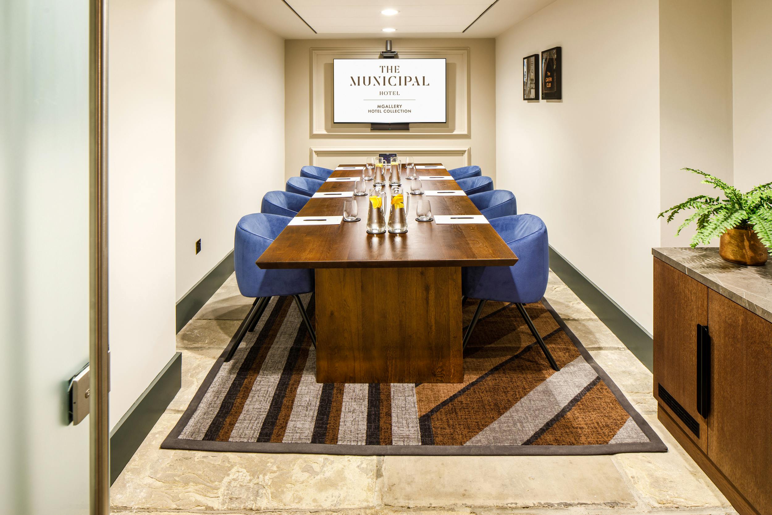 Cavern meeting room at Municipal Hotel Liverpool with wooden table and blue chairs.