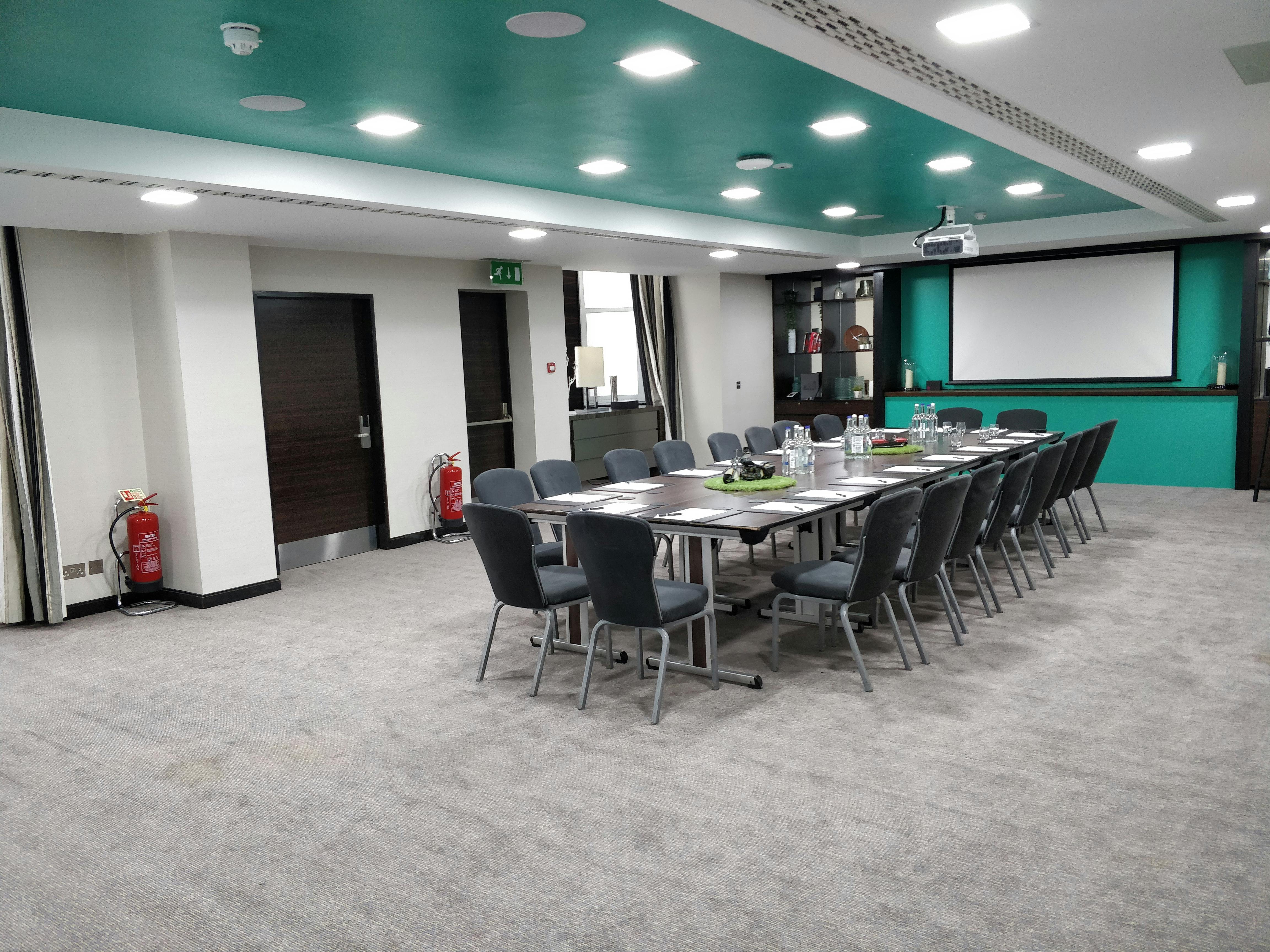 Cromwell 1 meeting room at DoubleTree London, featuring a teal accent wall for events.