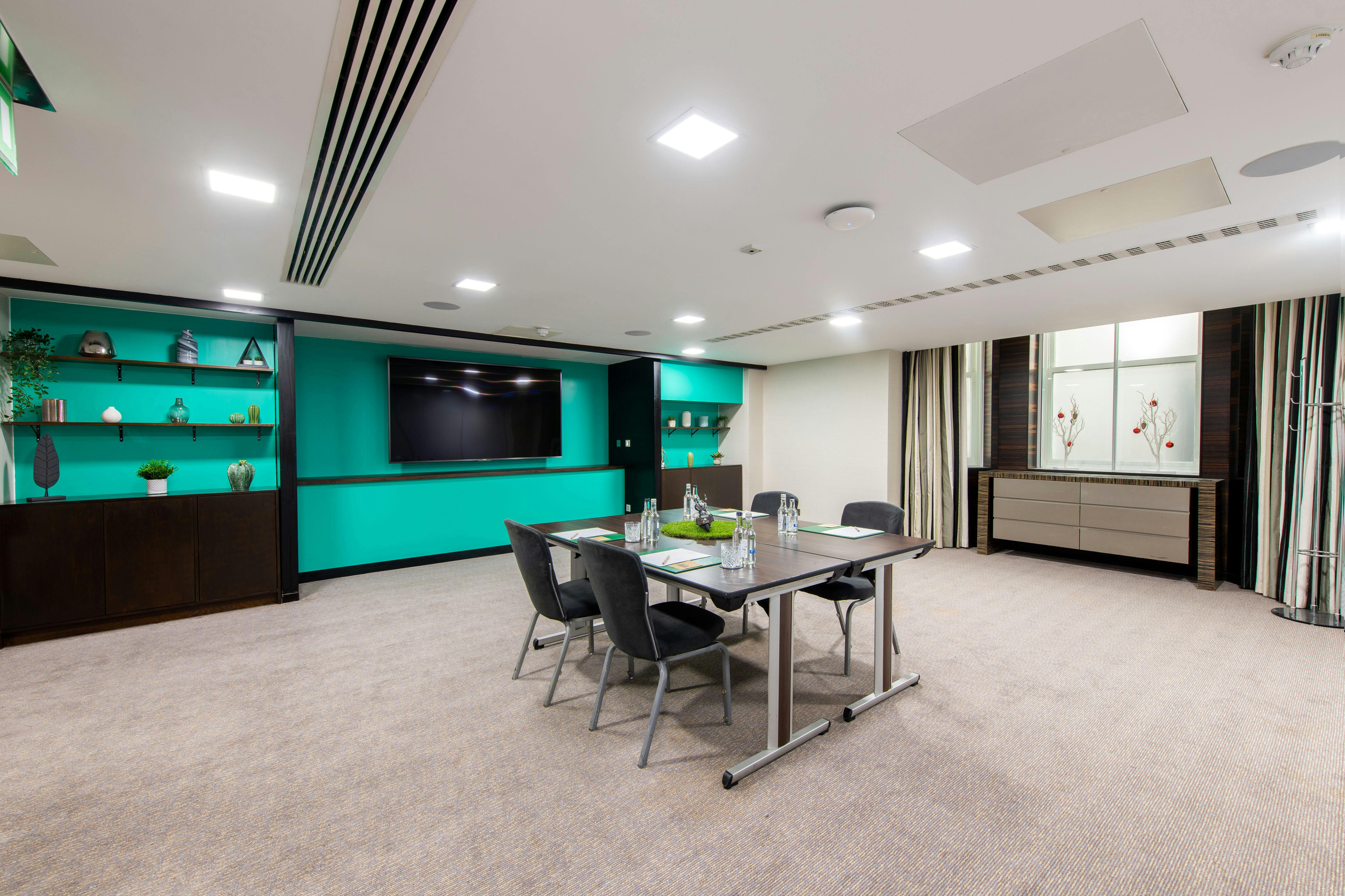 Modern meeting room at DoubleTree London Kensington with teal accents for versatile events.