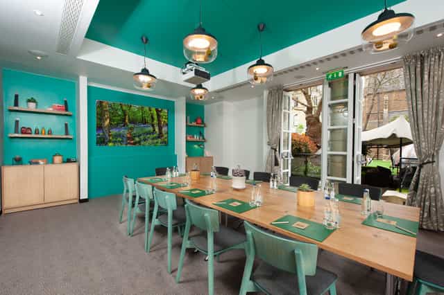 Modern meeting room with wooden table, ideal for workshops at DoubleTree London Kensington.