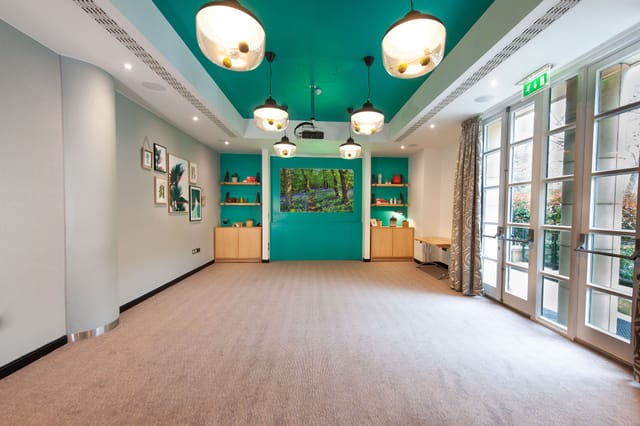 Garden Room at DoubleTree London Kensington, vibrant teal wall, ideal for meetings and events.