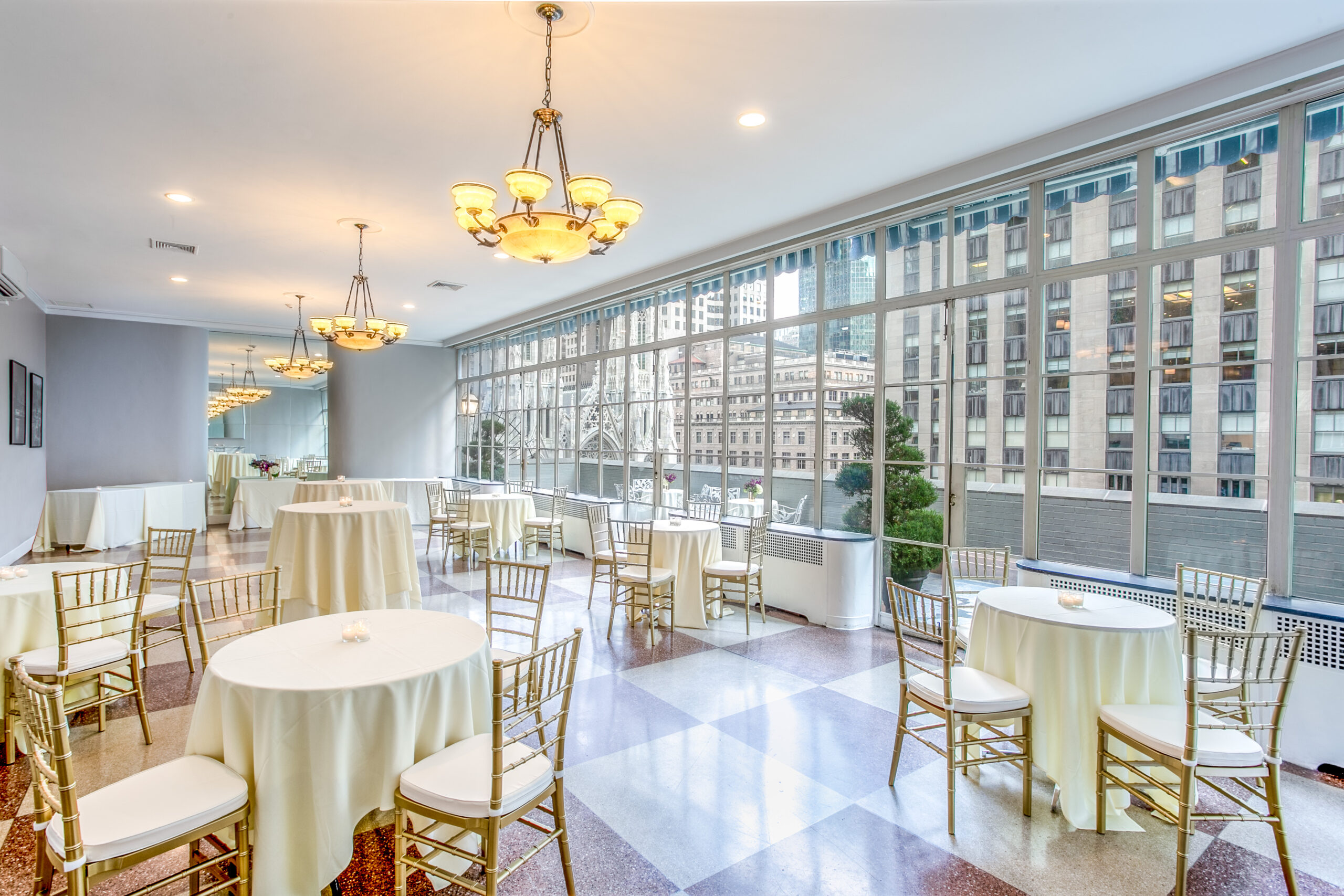 Elegant Solarium at 3 West Club, featuring round tables and city views for events.