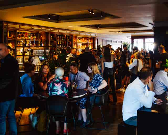 Vibrant networking event at NEON194 bar with modern decor and engaged attendees.