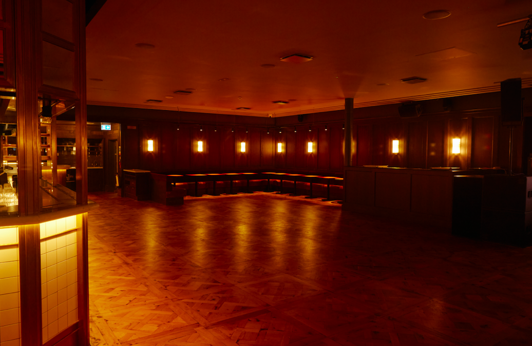 Alt text: "The Ballroom in NEON194, a warm-lit event space with polished wooden floor for gatherings." - Banner