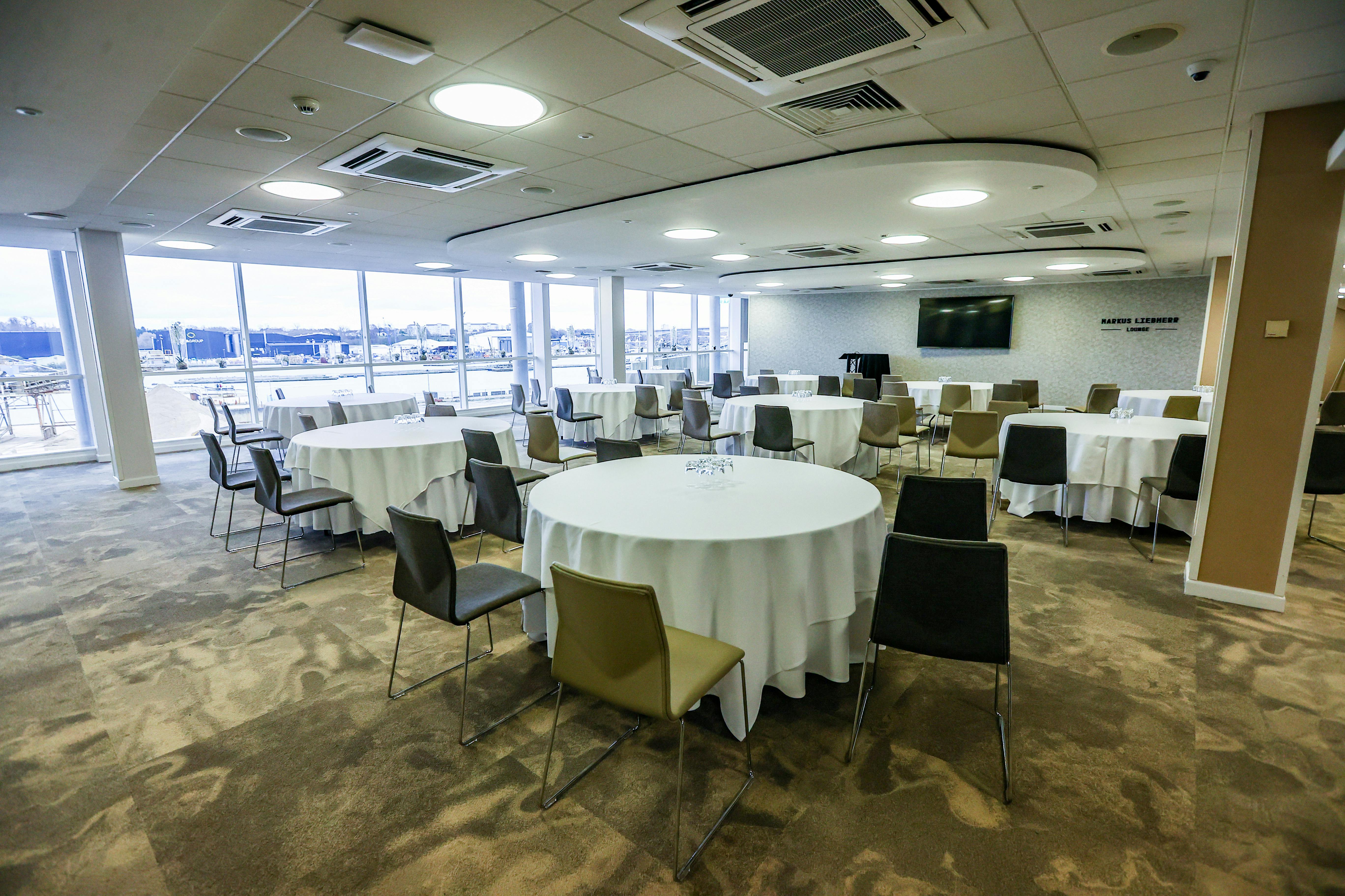 Markus Liebherr Lounge at Southampton FC, featuring round tables for versatile events.