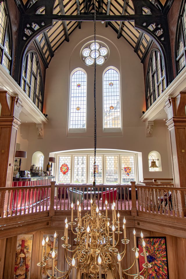 Elegant Main Dining Room at Mosimann's with stained glass, ideal for events and receptions.