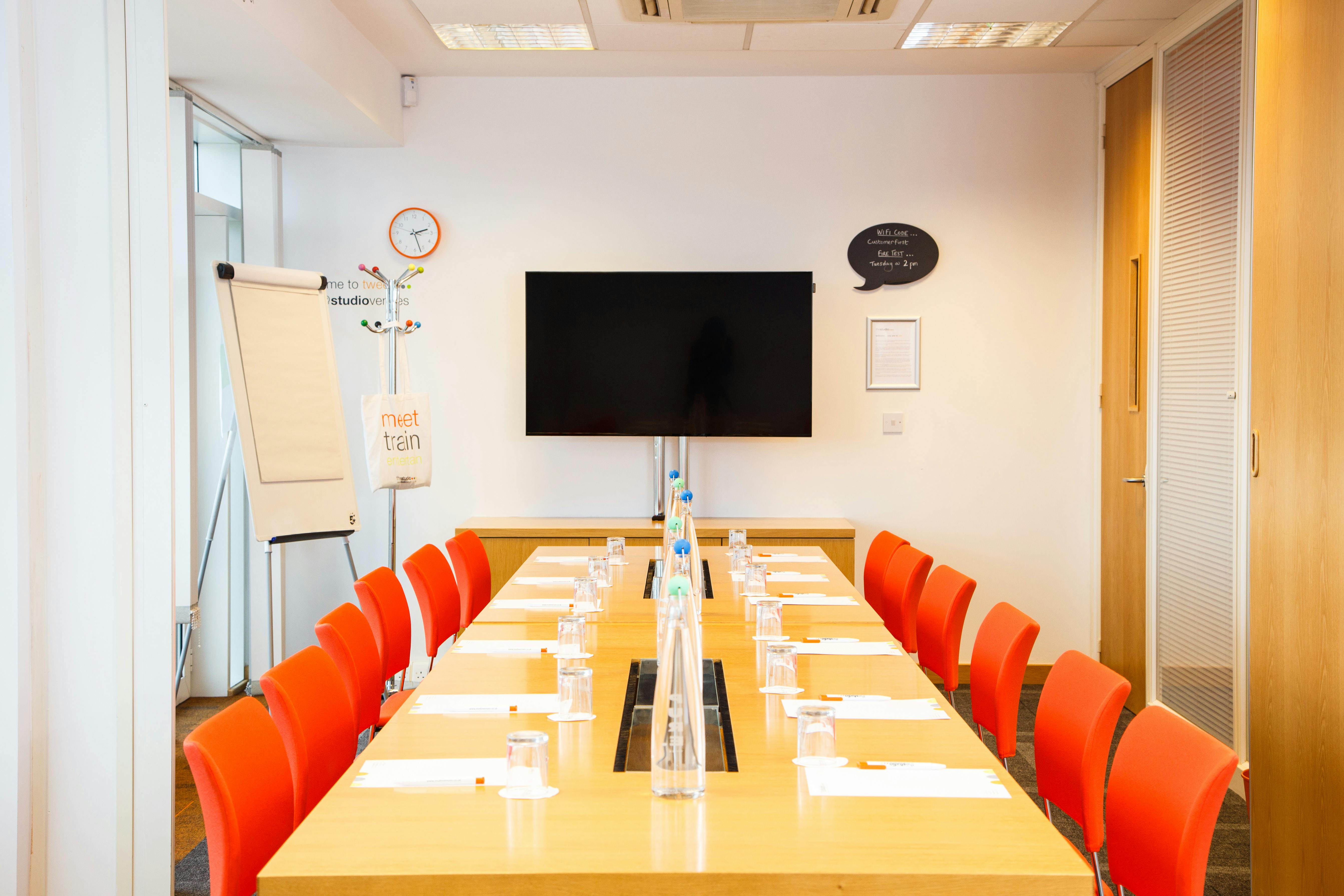 "Rock and Roll studio meeting room with orange chairs for collaborative brainstorming sessions."