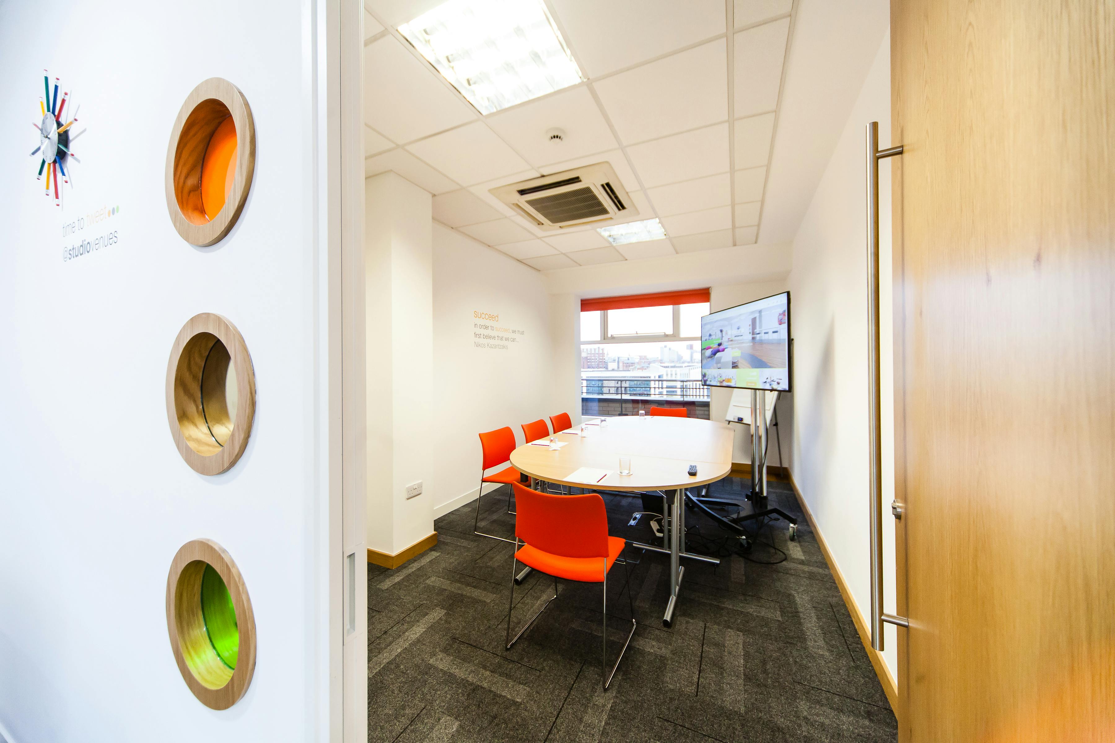 Modern meeting room in Leeds with round table, ideal for brainstorming and presentations.