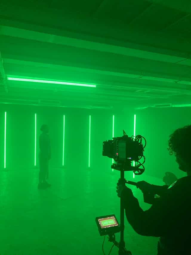 Back room at Strange Brew with green lighting, ideal for immersive events and performances.