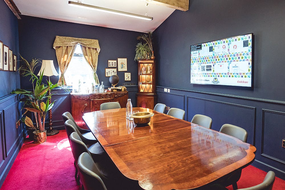 Intimate meeting room with blue walls, wooden table, perfect for events and presentations.