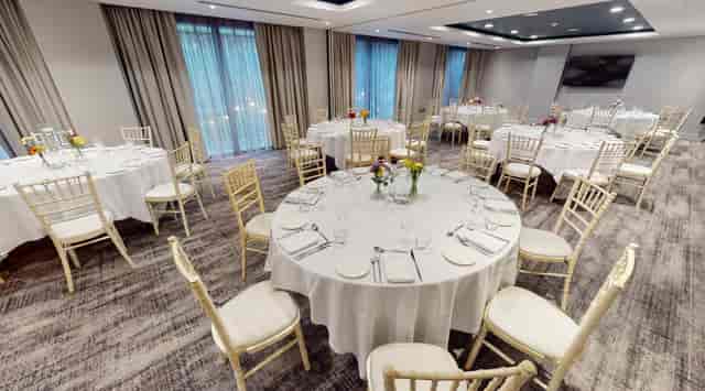 Wilson Suite at Holiday Inn Manchester: elegant event space with round tables for gatherings.