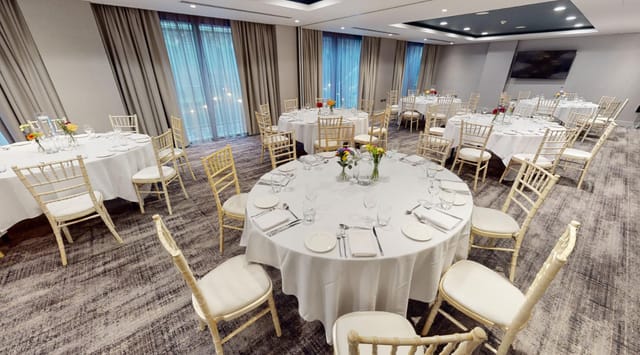 Wilson Suite at Holiday Inn Manchester: elegant event space with round tables for gatherings.