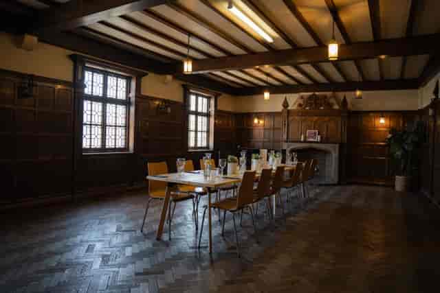 Meeting room with long table, warm wood decor for workshops and gatherings.