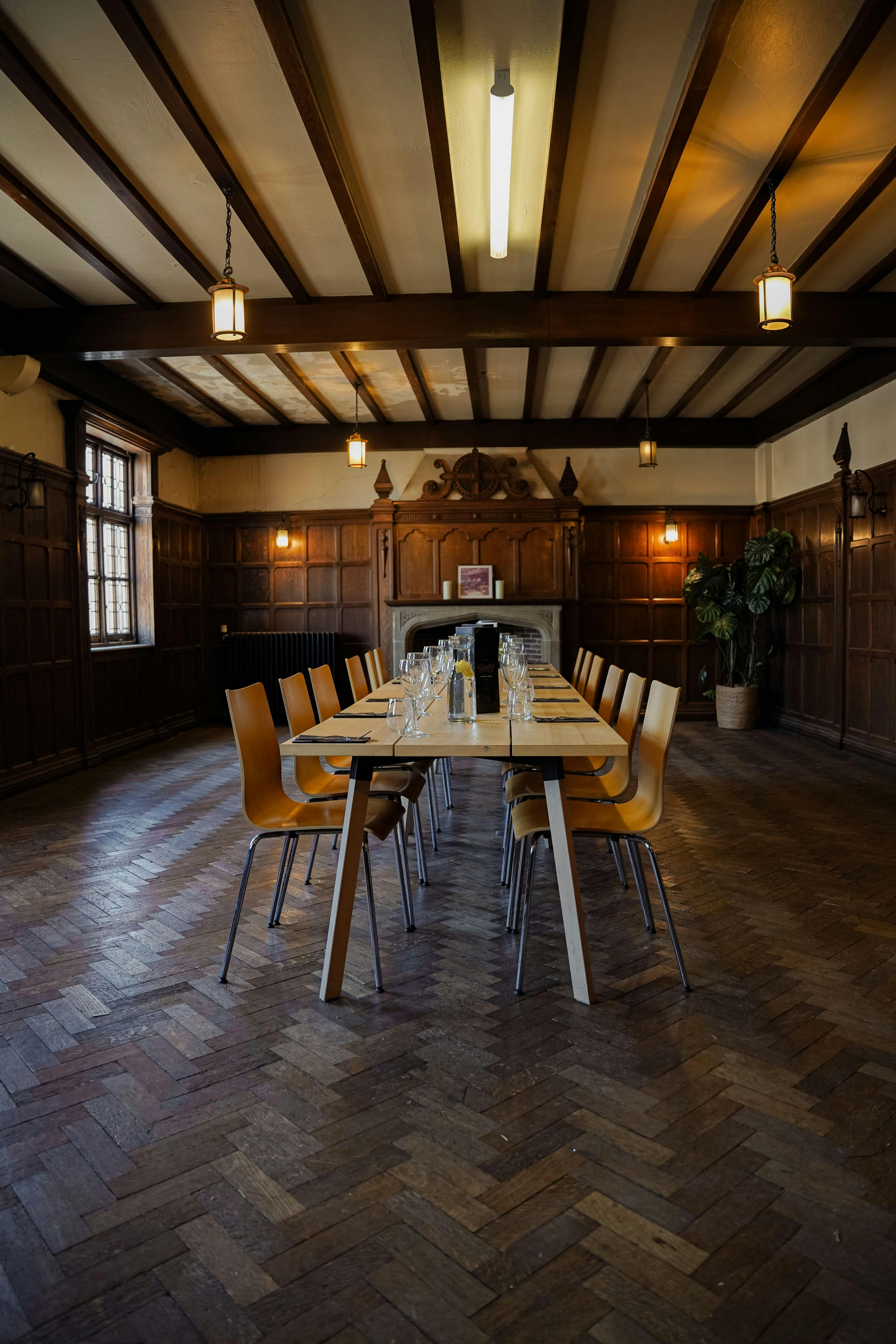 Intimate meeting space with long table, warm wood decor for workshops or events.