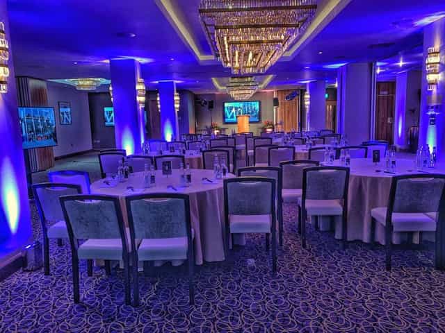 Citi 2 event space with round tables and blue lighting for corporate gatherings.