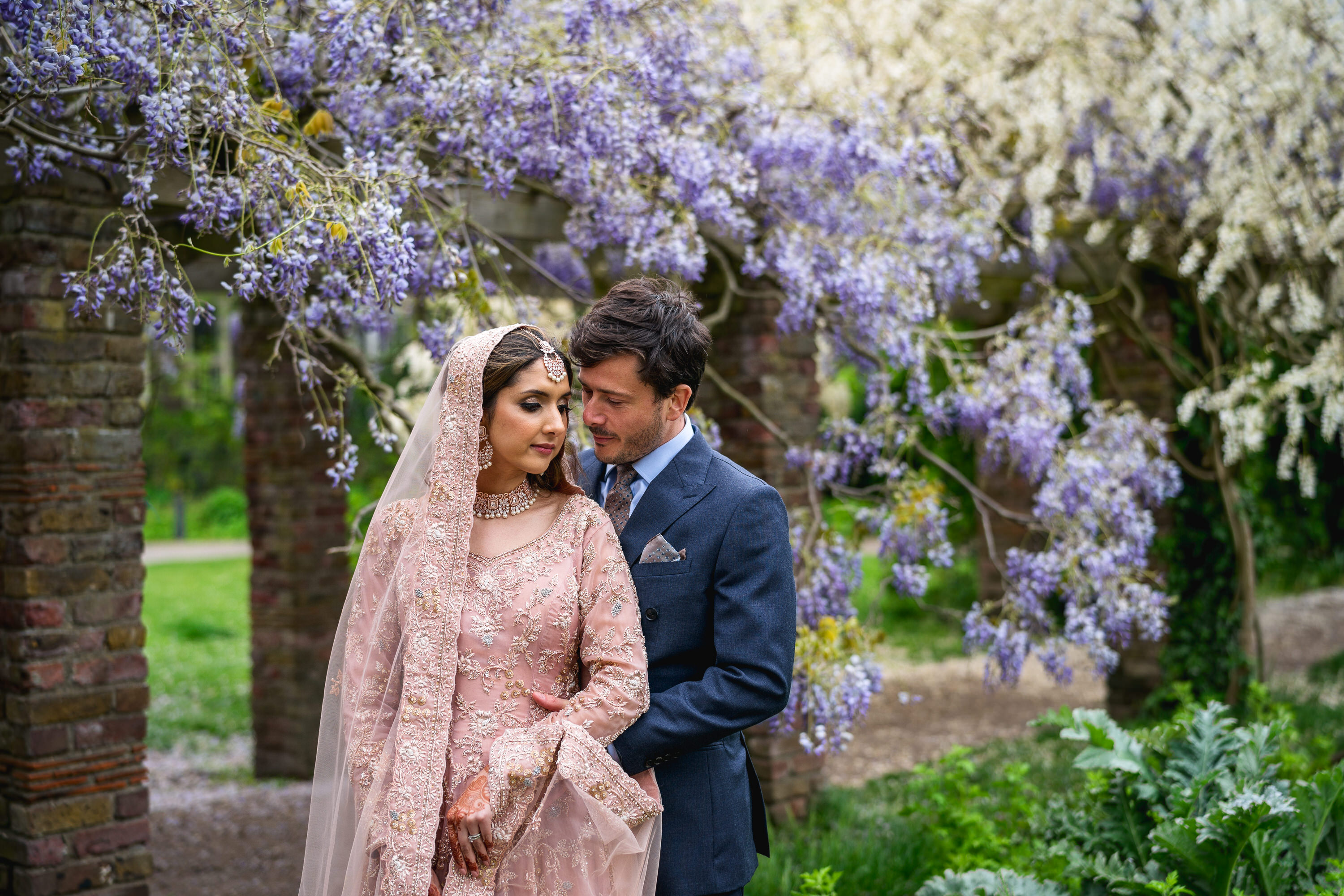 Couple under floral archway in Soane's Garden Room, ideal for weddings and romantic events. - Banner