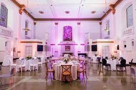 Elegant event space at The Nave, featuring round tables and floral arrangements for weddings.