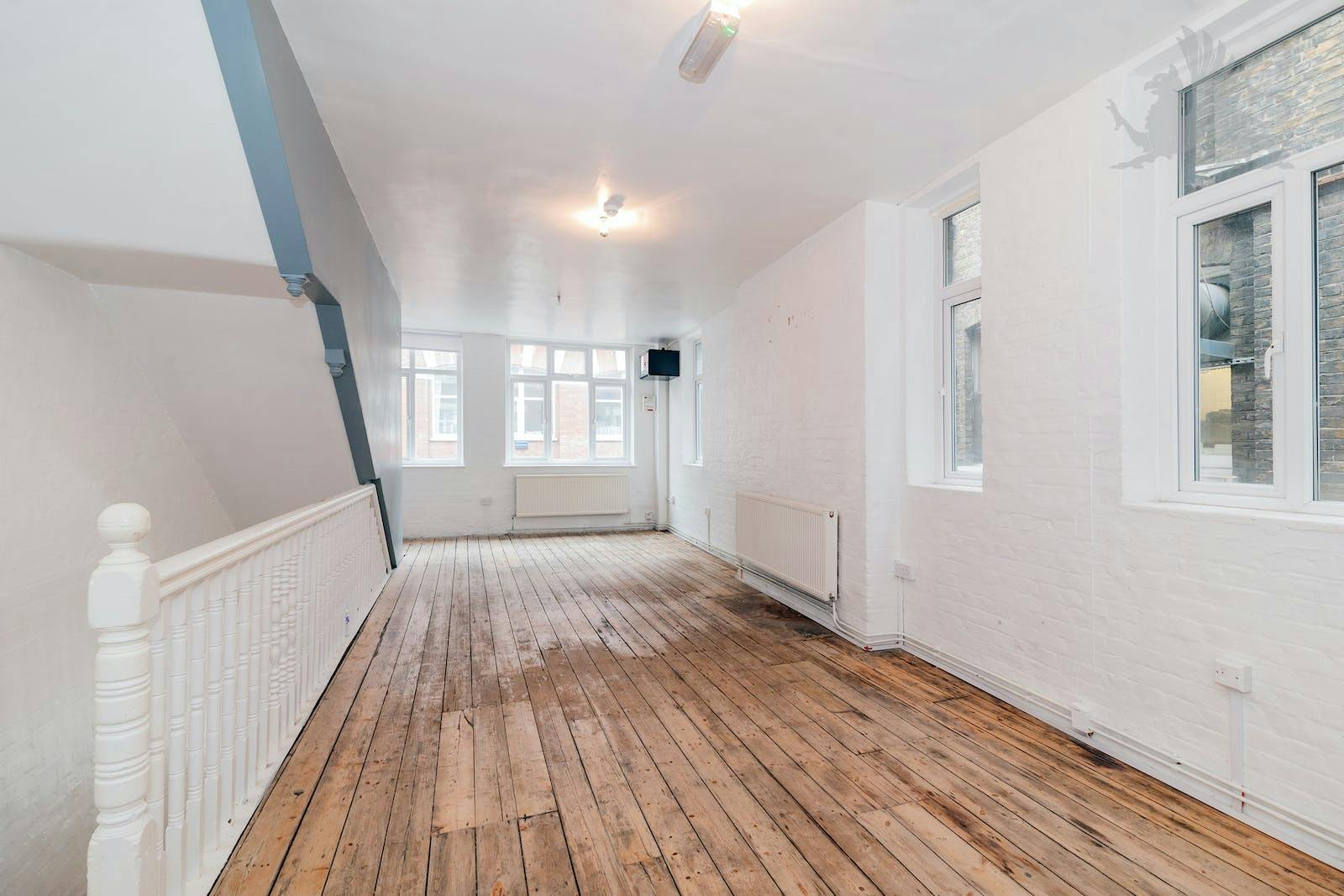 Versatile event space with natural light and wooden flooring for meetings and workshops.