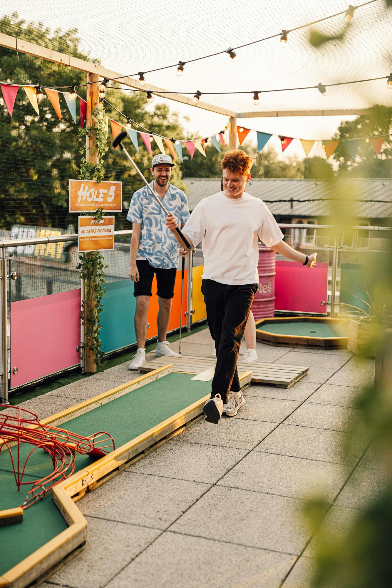 Vibrant outdoor event space at Caddies Crawley with colorful bunting for gatherings.