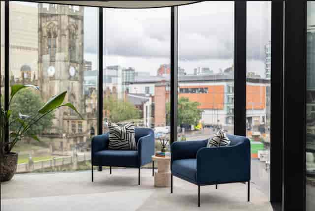 Modern meeting space with blue chairs and city views at x+why 100 Embankment.