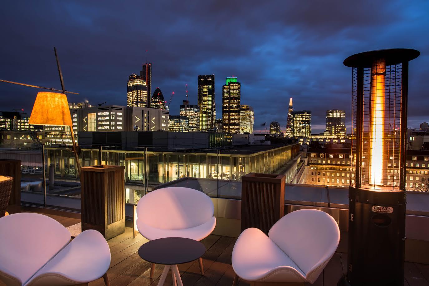 Rooftop venue with skyline view, modern seating for evening events and gatherings. - Banner